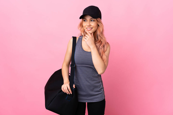 Teenager sport woman with sport bag over isolated background looking to the side and smiling - Fotografie, Obrázek