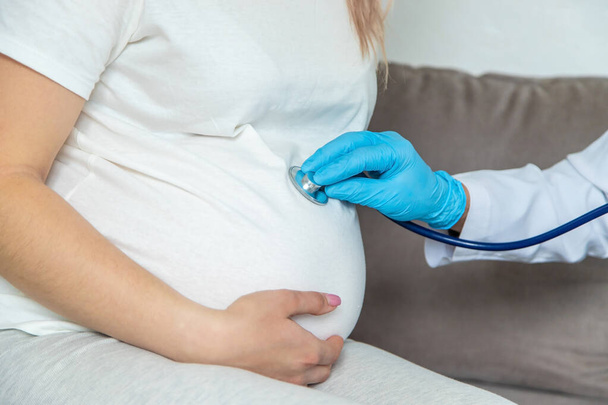 Le médecin examine le ventre d'une femme enceinte. Concentration sélective. médecine. - Photo, image