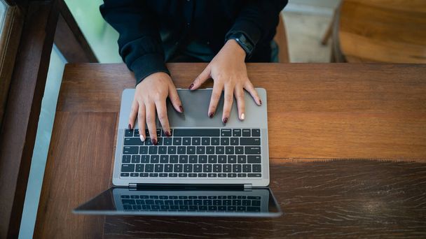 top view kezét az üzleti szabadúszó vállalkozó nő fehér fejhallgató dolgozik gépelés billentyűzet laptop és a fa asztal a kávézó. Üzleti technológiai koncepció. - Fotó, kép