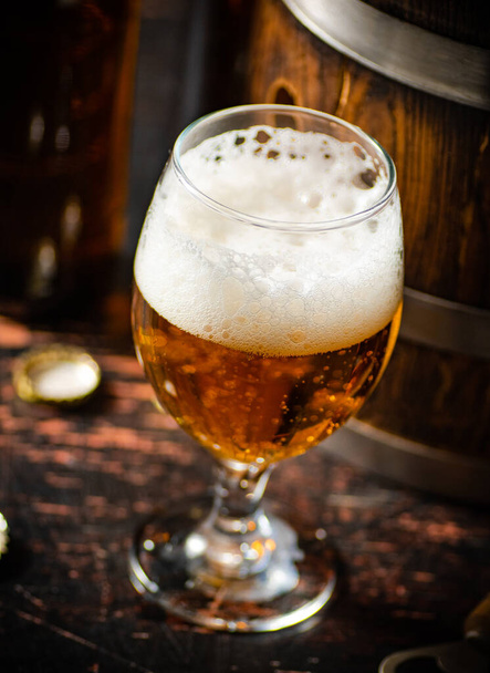 Glass with fresh beer. On rustic background. - Foto, afbeelding