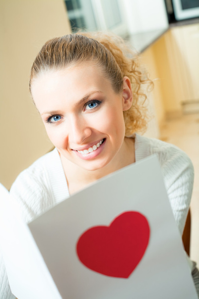 Young happy smiling beautiful woman, reading valentine card at home - Foto, Imagen