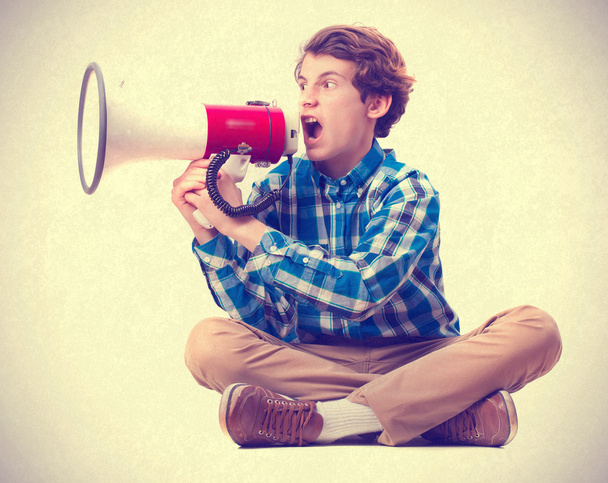 teenager shouting by megaphone - Фото, изображение