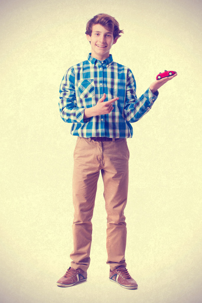 teenager holding a car toy - Фото, изображение