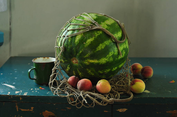 round green watermelon in peel and bag on wooden table - Zdjęcie, obraz