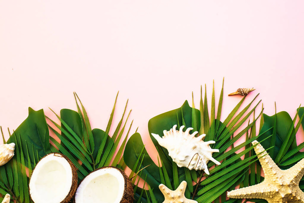 Summer flat lay background. Tropical leaves, palm leaves, coconut and sea shells on pink background. - Zdjęcie, obraz