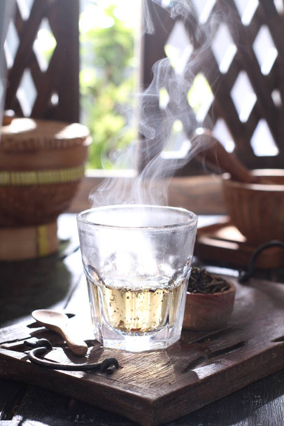 hot tea with lemon and ice on wooden table  - Фото, зображення