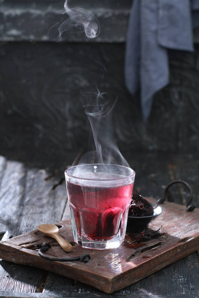 hot tea with red smoke on a wooden background - Foto, afbeelding