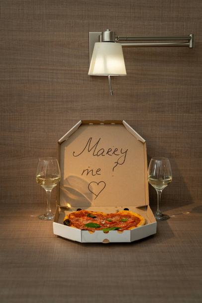 Una romantica proposta d'amore con deliziosa pizza e l'iscrizione sulla scatola di Merry Me. Foto di alta qualità - Foto, immagini