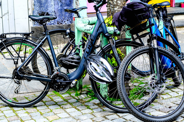 Stavanger, Rogaland, Noruega, 19 de maio de 2023, Bicicletas estacionadas e protegidas em um pavimento de alta rua no centro de Stavanger sem pessoas - Foto, Imagem