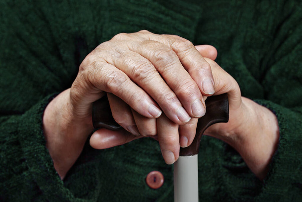 Mani di una donna anziana su un bastone, primo piano - Foto, immagini