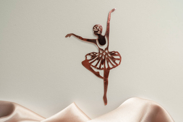 Paper pink ballerina performing a pirouette on a background of pink draped fabric. Background picture - Foto, Imagem