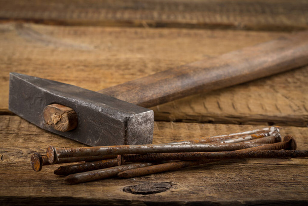 Vintage old hammer with rusty nails on wood table background - Valokuva, kuva