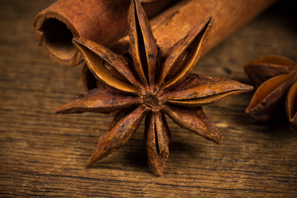 Close up of cinnamon sticks and star anise on rustic wood background - Foto, imagen