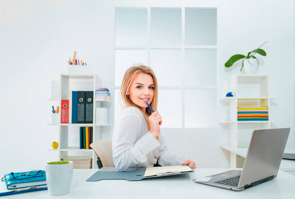 Beautiful young woman working in office. Business people - happy businesswoman or secretary with notebook at office - Fotoğraf, Görsel