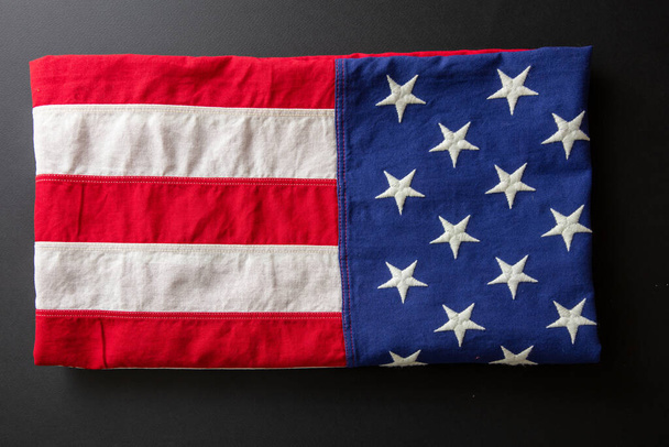 Amerikai zászló összehajtva a fekete támaszponton, felülnézetből. Amerikai Egyesült Államok Nemzeti ünnep, emlékmű és függetlenség napja - Fotó, kép