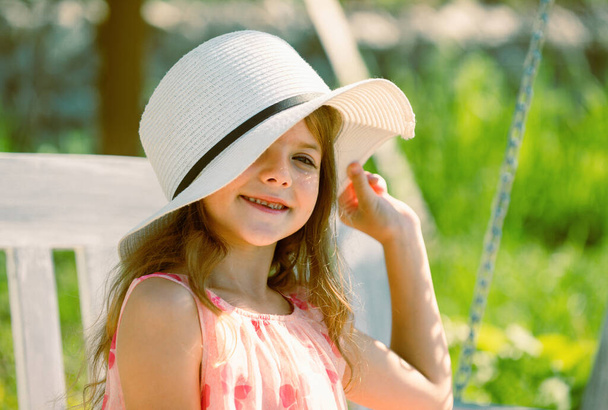 Adorable little girl portrait closeup outdoors in summer. Happy child relax in summer green background - Fotó, kép