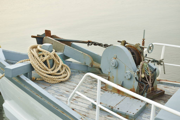 iron boat winch and anchor at ship prow in river on sunset - Photo, Image