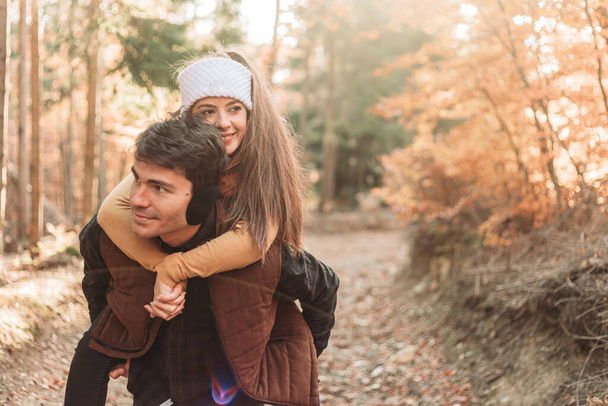 Young romantic couple in the woods. Piggyback riding. Happy together - Φωτογραφία, εικόνα