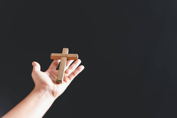 Close up Christian woman hands holding a cross holy and worship. Spirituality and religion Concept, Person holding christian cross to making pray indoors. Believe and faith for christian people. - Foto, Imagem