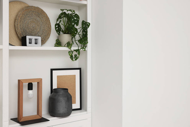 Shelves with different decor near white wall, space for text. Interior design - Fotografie, Obrázek