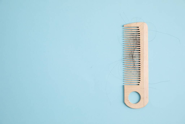 Wooden comb with lost hair on light blue background, top view. Space for text - Zdjęcie, obraz