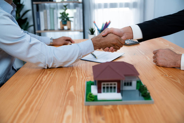Успешный договор займа на дом запечатан рукопожатием. Покупатели и агенты отмечают право собственности на недвижимость с чувством завершенности и удовлетворения. Пылкий - Фото, изображение