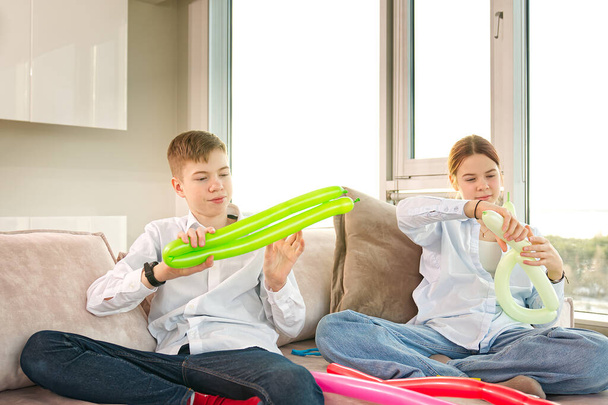 Children inflate modelling balloons. kids having fun with balloons at home - Foto, Imagem