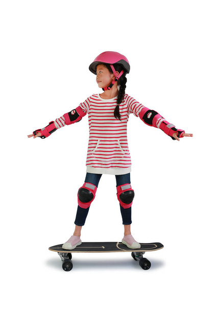 Asian little girl kid skateboarder with wearing safety and protective equipment stand on skateboard isolated on white background. Image with Clipping path. - Fotó, kép