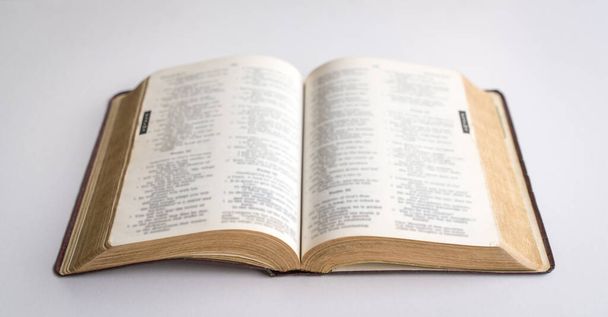 Holy Bible open in the centre. On white background. - 写真・画像