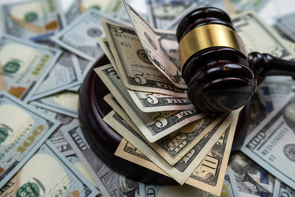 A bíró kalapácsa 100 dollárnyi új pénzen nyugszik, jogi koncepció. Jogi vagy bűnügyi - Fotó, kép