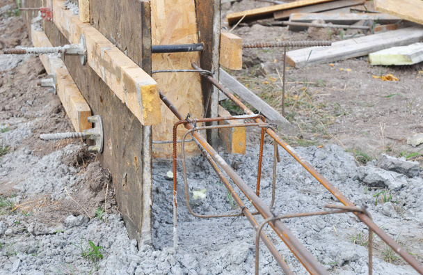 Tiivistää betonilla jalustalla laatoina. Kaada betoni pohjat puulaatat vahvistamalla baareja uuden talon perusta aidat. - Valokuva, kuva