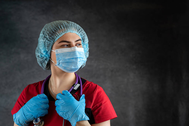портрет женщины-врача носить униформу с медицинской маской для лица и медицинскими перчатками, стетоскоп. Медицинская концепция - Фото, изображение