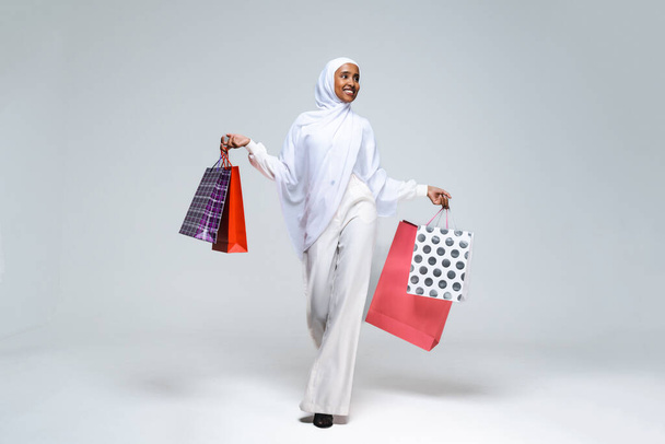 Belle femme arabe du Moyen-Orient avec robe traditionnelle abaya en studio - Femme noire africaine musulmane adulte portant un portrait vestimentaire arabe à la mode et élégant à Dubaï, Émirats arabes unis - Photo, image