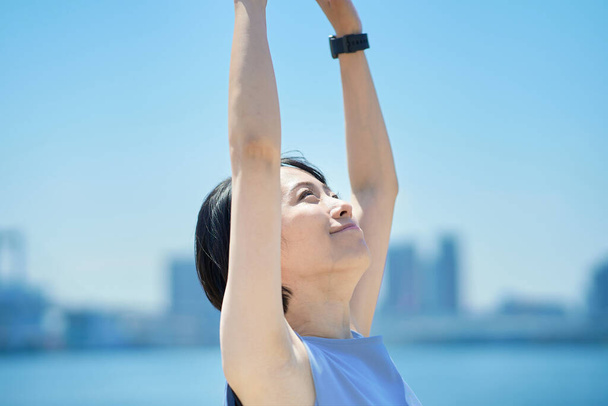 Eine Frau mit entspanntem Gesichtsausdruck unter blauem Himmel - Foto, Bild