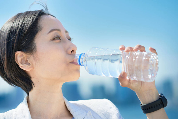 Nő ivóvíz egy műanyag palack szabadban - Fotó, kép