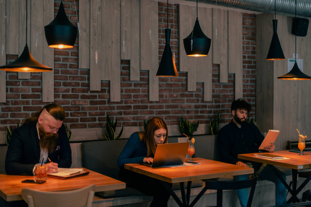 Snímek tří podnikatelů pracujících společně na jednom projektu v kavárně - Fotografie, Obrázek