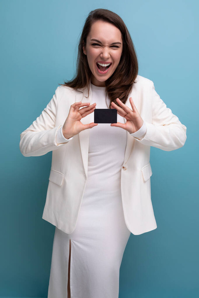 energetic brunette woman in office dress pays for the purchase using a card and phone. - Photo, Image