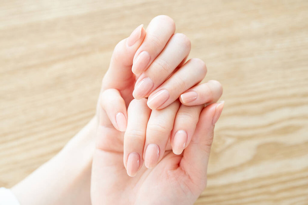 A mão de uma mulher verificando a condição de suas unhas                 - Foto, Imagem