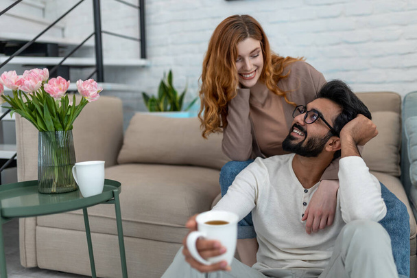 Affectionate loving married couple drinking coffeee, enjoying spending time together at home, relaxing, sweet tender moment. - Photo, Image