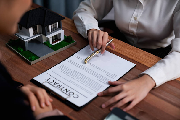 Completando la fase finale del processo di prestito casa, l'acquirente firma il contratto di prestito carta con una penna sulla scrivania, assicurando la proprietà della proprietà. Entusiasta - Foto, immagini