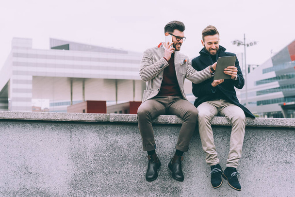 Two young businessman tablet outdoor sitting - Photo, Image