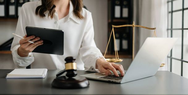 justice and law concept.female judge in a courtroom  with the gavel, working with  laptop and digital tablet computer - Foto, afbeelding