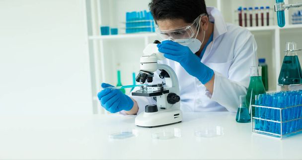 Tıbbi, analitik, tıbbi, ilaç ve bilimsel araştırma konseptleri için sıvıyla cam laboratuvarda kimyasal test tüpleri olan bir araştırmacı tıbbi araştırma klinikleri ve kimyasalları test tüpleri - Fotoğraf, Görsel
