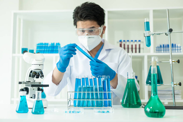 Investigador con tubos de ensayo químicos en un laboratorio de vidrio con líquido para conceptos analíticos, médicos, farmacéuticos y científicos Tubos de ensayo en clínicas de investigación médica y productos químicos - Foto, Imagen