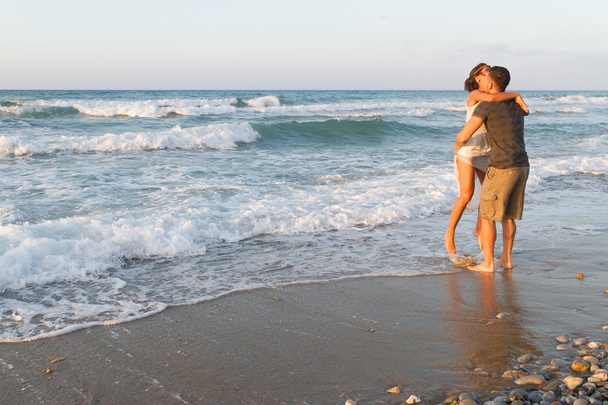 Jeune couple aime marcher sur une plage brumeuse au crépuscule
. - Photo, image