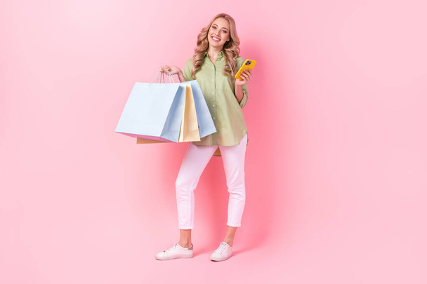 Full length photo of adorable shiny lady wear green shirt online order bargains modern gadget isolated pink color background. - Fotografie, Obrázek