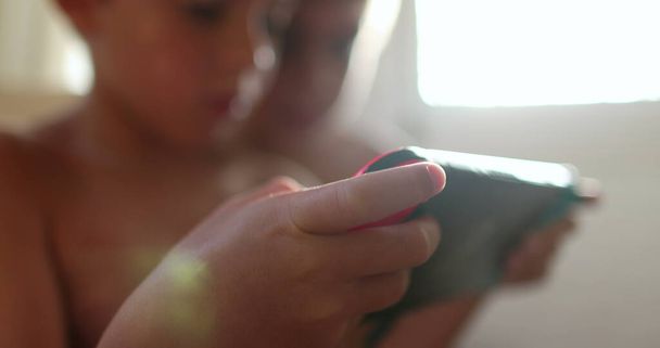 Child hand holding video-game controller playing online, close-up of kid hands holding joystick game - Foto, Imagem
