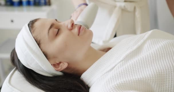 Modern technic. LPG skin massage in a professional beauty studio. Beautician makes ultrasound facial massage. Facial rejuvenation procedure. Face beauty treatment with beauty woman. - Footage, Video