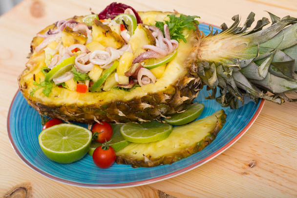 Salad with squid, pineapple and lime dressed with sauce of pineapple and lime juice, olive oil, chili pepper - Valokuva, kuva