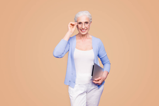 Grey haired old smiling business woman wearing glasses, holding tablet. Isolated over violet purple background. - Foto, Imagem
